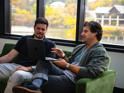 Two gentlemen having a meeting on a couch in an office overlooking the grand river