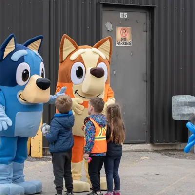Kids high fiving costumed cartoon mascots